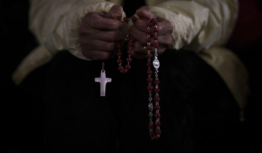 A Catholic woman attends a nightly rosary prayer service for the health of Pope Francis in St. Peter's Square at the Vatican, Wednesday, Feb. 26, 2025. (AP Photo/Bernat Armangue)