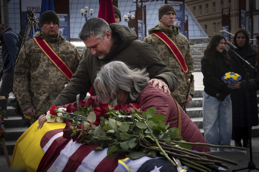 Parents of U.S. Marine Corps veteran Ethan Hertweck, 21, who lost his life in defending Ukraine against the Russian troops, react at a coffin during funeral ceremony in Independent Square in central Kyiv, Ukraine, Friday, Feb. 28, 2025. (AP Photo/Efrem Lukatsky)