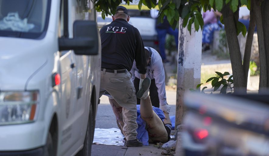 Forensic workers remove the body of the body of a slain woman in Culiacan, Mexico, Wednesday, Feb. 26, 2025. (AP Photo/Fernando Llano)