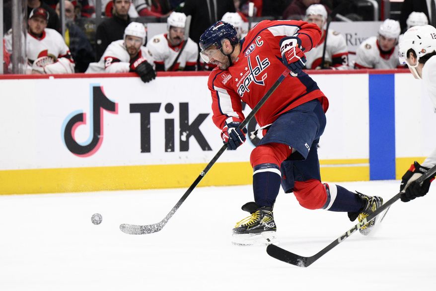 Washington Capitals left wing Alex Ovechkin, left, shoots the puck during the first period of an NHL hockey game against the Ottawa Senators, Monday, March 3, 2025, in Washington. (AP Photo/Nick Wass)
