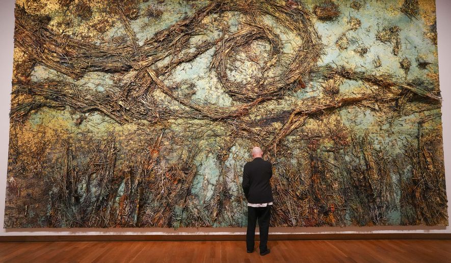 Anselm Kiefer adjust a piece of his artwork The Starry Night during a press preview of the Anselm Kiefer exhibit at the Van Gogh Museum and Stedelijk Museum in Amsterdam, Netherlands, Wednesday, March 5, 2025. (AP Photo/Peter Dejong)