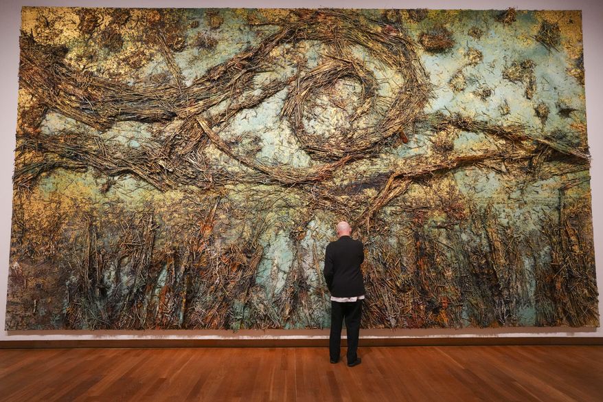 Anselm Kiefer adjust a piece of his artwork The Starry Night during a press preview of the Anselm Kiefer exhibit at the Van Gogh Museum and Stedelijk Museum in Amsterdam, Netherlands, Wednesday, March 5, 2025. (AP Photo/Peter Dejong)