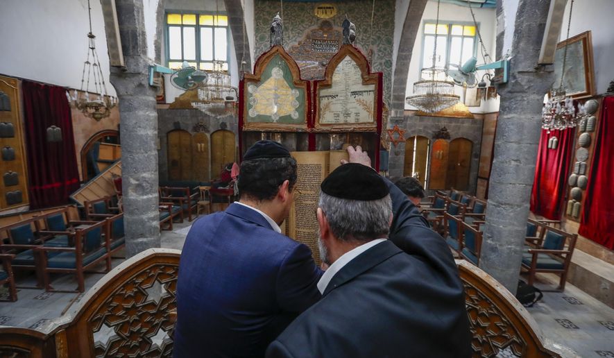 FILE - Rabbi Yusuf Hamra, right, and his son Henry lookout an old scripture at the Efranj synagogue in the old city of Damascus Feb. 18, 2025. The Syrian-American Jewish family returned for the first time since emigrating from Syria to the United States more than three decades ago. (AP Photo/Omar Sanadiki, File)