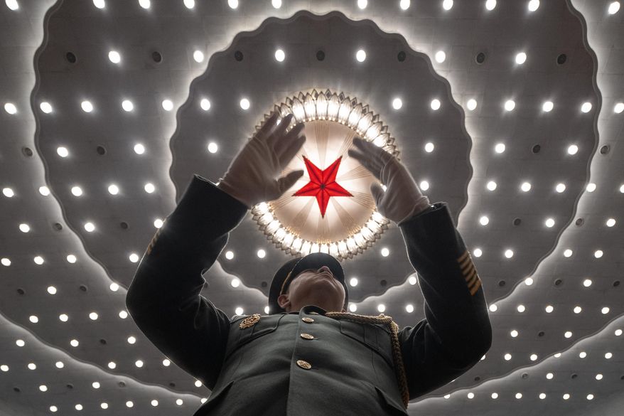 A Chinese military band conductor leads the band at the closing ceremony of the National People's Congress held at the Great Hall of the People in Beijing, Tuesday, March 11, 2025. (AP Photo/Ng Han Guan)