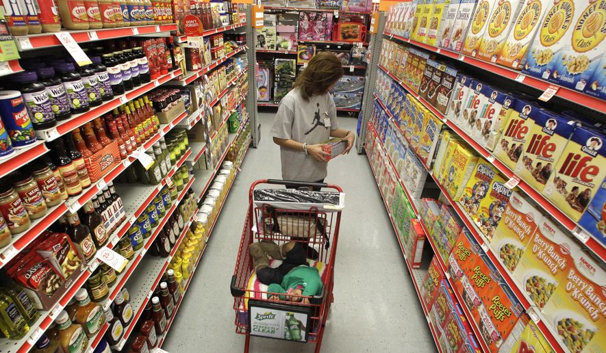 A woman looks at products in the aisle of a store as her daughter naps in the shopping cart in Waco, Texas, on Dec. 14, 2010. (AP Photo/Tony Gutierrez, File)