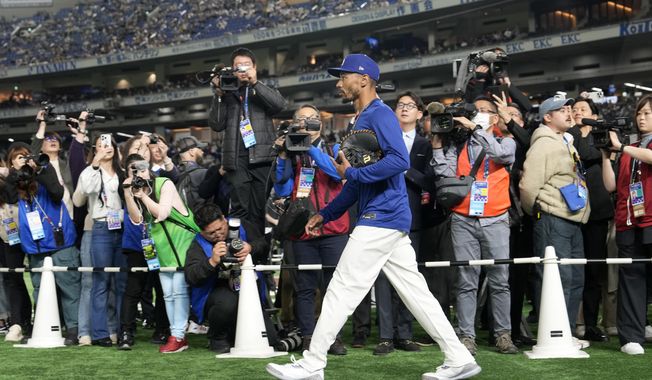 Los Angeles Dodgers' Mookie Betts walks onto the field before an MLB Japan Series exhibition baseball game against the Hanshin Tigers, Sunday, March 16, 2025, in Tokyo. (AP Photo/Eugene Hoshiko)