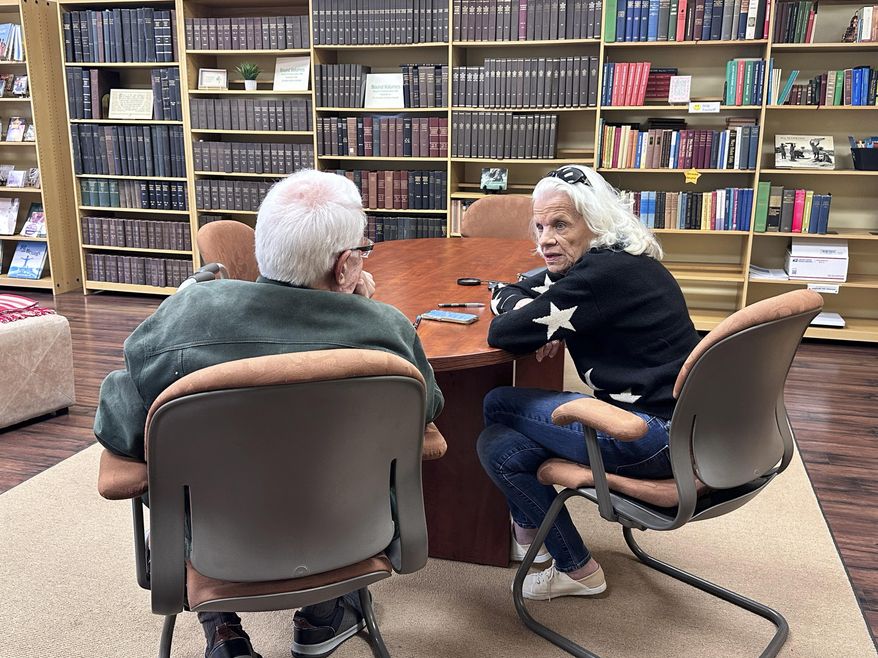 Mike Van Vleck, left, and Gail Dowdle talk while volunteering at the Christian Science Reading Room in downtown Overland Park, Kans., Friday, March 14, 2025. (Kit Doyle/Religion News Service via AP)