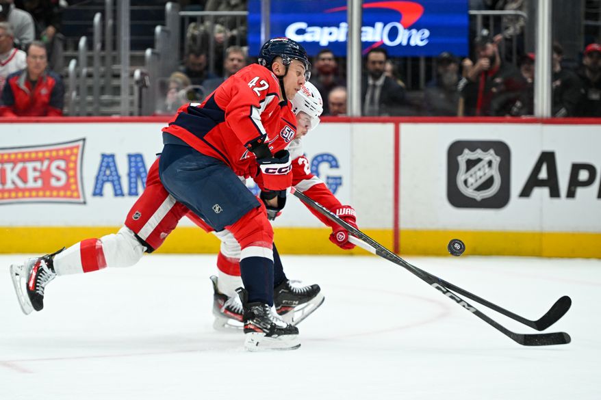 Washington Capitals defenseman Martin Fehervary (42) fighting with Detroit Red Wings forward Lucas Raymond (23) for the puck during the first period of an NHL game against the Detroit Red Wings at Capital One Arena in Washington D.C., March 18, 2025. (Photo for the Washington Times)