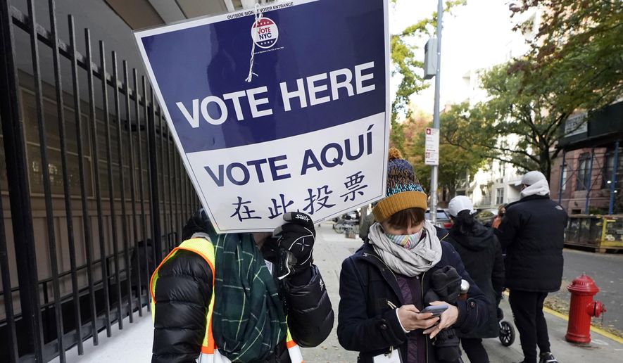 FILE — Poll workers direct voters outside Frank McCourt High School on New York's Upper West Side, Nov. 3, 2020. (AP Photo/Richard Drew, File)
