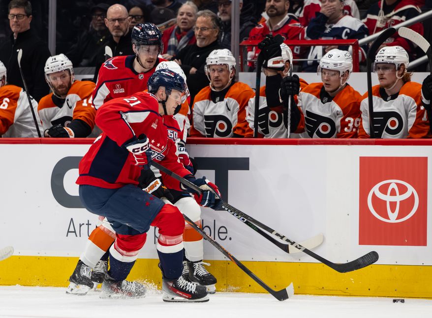 Washington Capitals center Aliaksei Protas (21) slams against his opponent gaining control of the puck at a hockey game against the Philadelphia Flyers on March 20 2025 at Capital One Arena in Washington D.C. (Alyssa Howell/ Washington Times)
