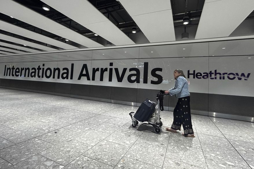 A traveller arrives at Terminal 5 as Heathrow Airport slowly resumes flights after a fire cut power to Europe's busiest airport in London, Saturday, March 22, 2025.(AP Photo/Kirsty Wigglesworth)