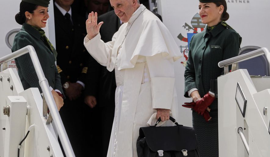 In this May 12, 2017 file photo, Pope Francis holds his bag and waves as he embarks his flight to Monte Real, Portugal, from Rome's International airport of Leonardo Da Vinci, in Fiumicino, Italy. (AP Photo/Gregorio Borgia, file)