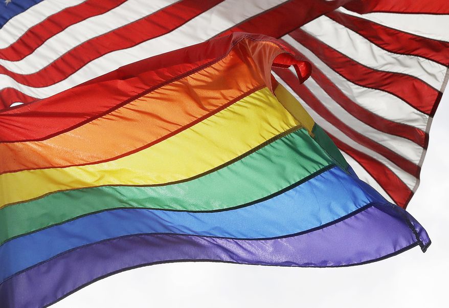 FILE - The LGBTQ+ pride flag flies beneath the American flag at the Stonewall National Monument, Oct. 11, 2017, in New York. (AP Photo/Mark Lennihan, File)