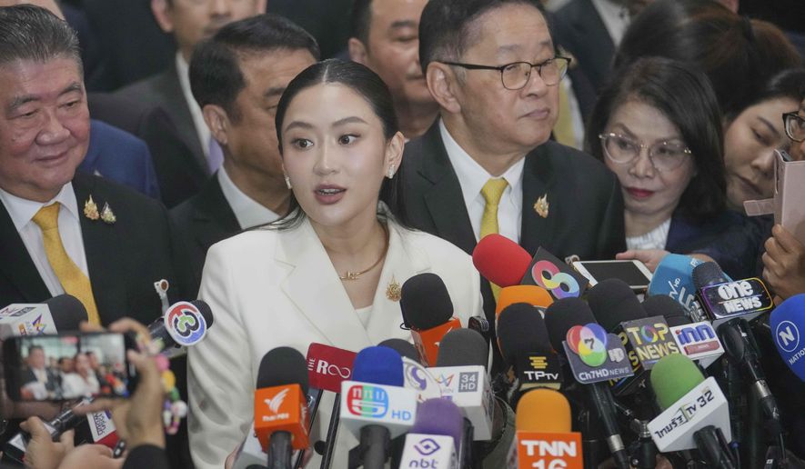 Thailand's Prime Minister Paetongtarn Shinawatra, center, answers questions from reporters on her arrival at the Parliament before a no-confidence debate against the prime minister in Bangkok, Thailand, Monday, March 24, 2025. (AP Photo/Sakchai Lalit)