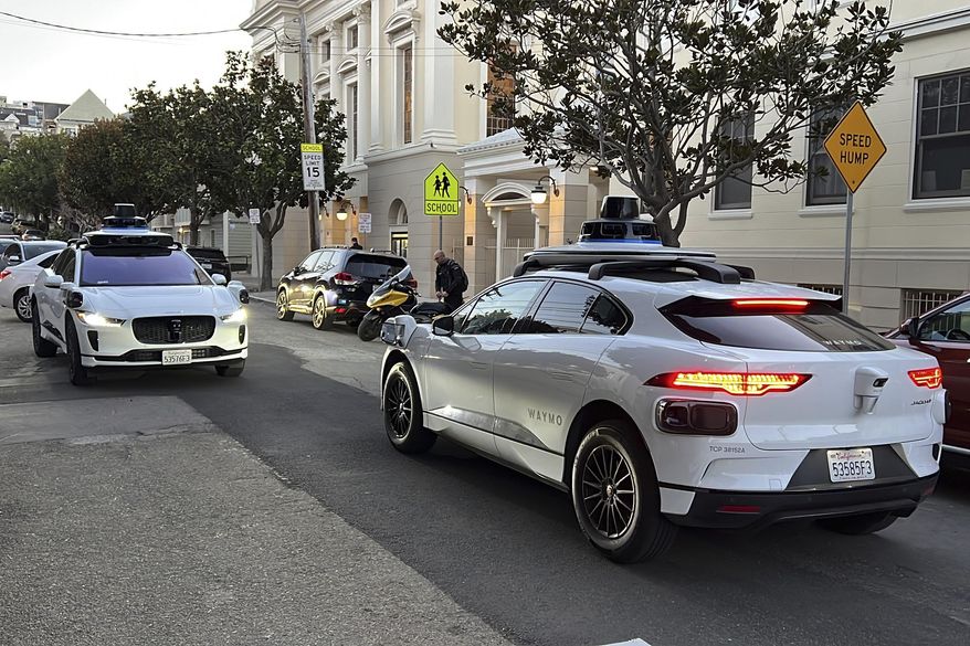 Two Waymo driverless taxis stop before passing one another on a San Francisco street on Feb. 15, 2023. (AP Photo/Terry Chea) **FILE**
