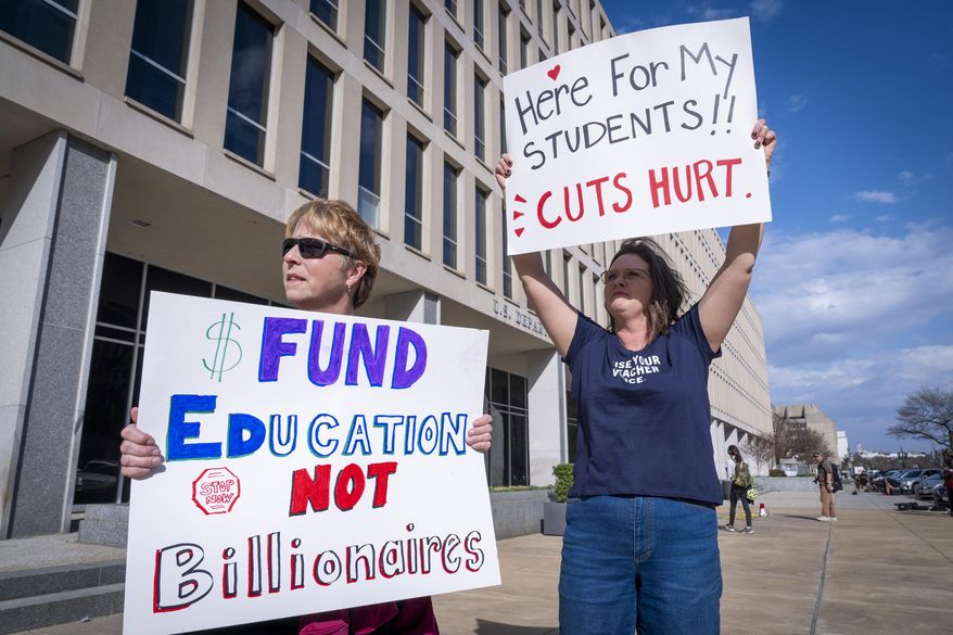 High School teacher June Kelly, left, and SJ Marcotte, right, who teaches business leadership, both with a group of educators from Vermont, hold signs in support of the Department of Education, Thursday, March 20, 2025, outside the department in Washington. (AP Photo/Jacquelyn Martin) ** FILE **