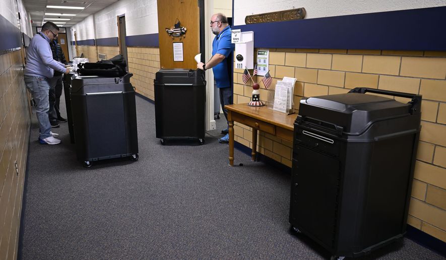 Christopher Prue, president of the Registrars of Voters Association of Connecticut, right, moves new voting tabulators out of his office at the Registrars of Voters to be redistributed to other towns, Thursday, March 27, 2025, in Vernon, Conn. (AP Photo/Jessica Hill)