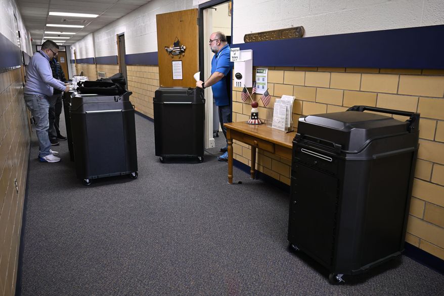 Christopher Prue, president of the Registrars of Voters Association of Connecticut, right, moves new voting tabulators out of his office at the Registrars of Voters to be redistributed to other towns, Thursday, March 27, 2025, in Vernon, Conn. (AP Photo/Jessica Hill)