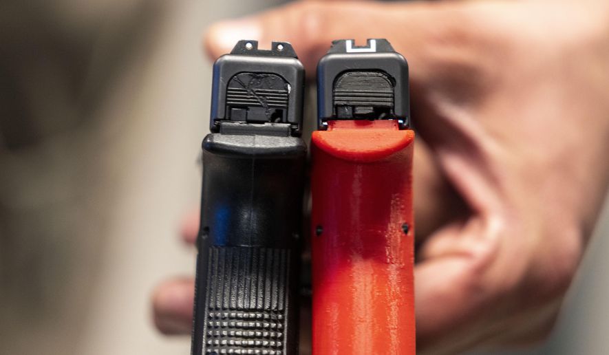 Two semi-automatic pistols are displayed for a photograph, one with a conversion device installed making it fully automatic, at the Bureau of Alcohol, Tobacco, Firearms, and Explosives (ATF), National Services Center, Thursday, March 2, 2023, in Martinsburg, W.Va. (AP Photo/Alex Brandon, File)