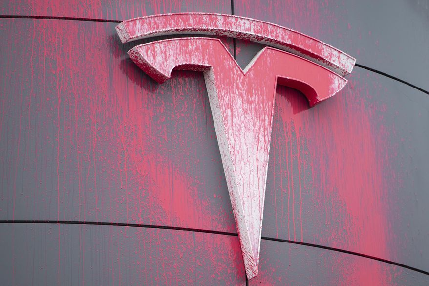 Pink spray paint is seen on the Tesla logo of the Tesla Service and Showroom centre after being spray painted by a protester in Ottawa, Canada on Monday, March 31, 2025. (Spencer Colby/The Canadian Press via AP) **FILE**