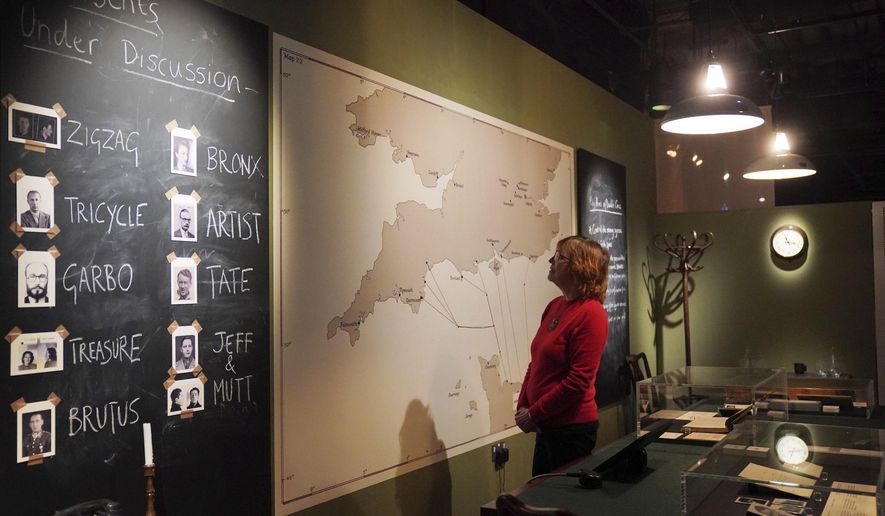National Archives staff members look at facets of a recreation of the double cross operation room which was headed up by the XX committee circa 1944, during a preview for the MI5: Official Secrets exhibition at the National Archives in London, Tuesday, April 1, 2025. (Jonathan Brady/PA via AP)