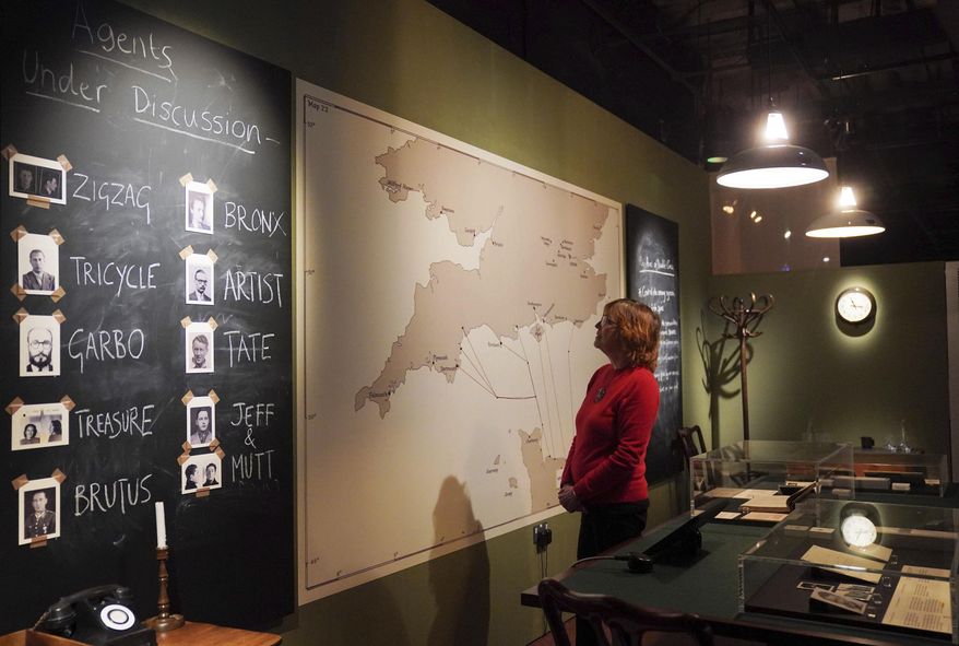 National Archives staff members look at facets of a recreation of the double cross operation room which was headed up by the XX committee circa 1944, during a preview for the MI5: Official Secrets exhibition at the National Archives in London, Tuesday, April 1, 2025. (Jonathan Brady/PA via AP)
