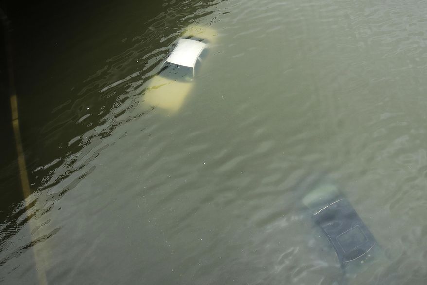 FILE - Cars are submerged on a freeway flooded in the aftermath of Hurricane Harvey near downtown Houston, Texas, on Aug. 27, 2017. (AP Photo/Charlie Riedel, File)