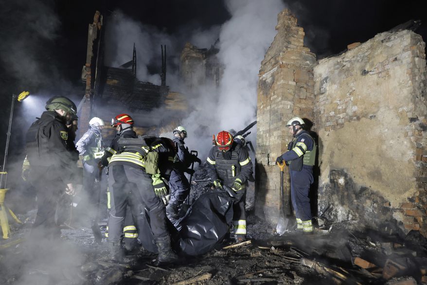 Rescuers carry the body of a killed resident following Russia's drone attack in Kharkiv, Ukraine, late Thursday, April 3, 2025. (AP Photo/Yevhen Titov)
