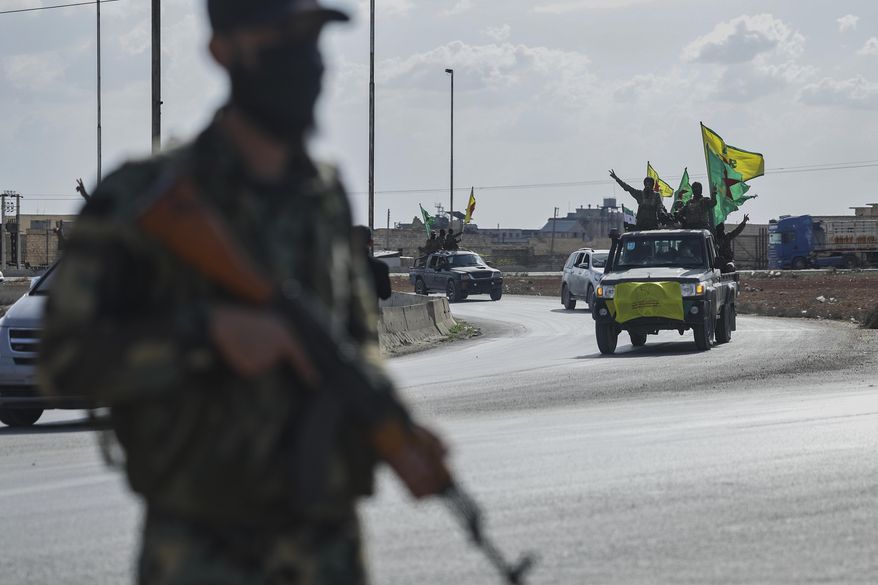 U.S.-backed Kurdish fighters stands on their vehicles, as they withdraw from two neighborhoods in Syria's northern city of Aleppo as part of a deal with the Syrian central government, in Aleppo, Syria, Friday, April 4, 2025. (AP Photo/Ghaith Alsayed)