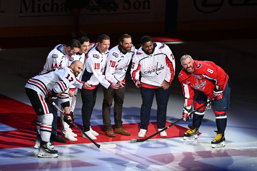 The Washington Capitals celebrate players from the franchise's fifth era (2014 to present), including (l to r) Brooks Orpik, TJ Oshie, Nicklas Backstrom, Braden Holtby and Devante Smith-Pelly. The players were flanked by Chicago Blackhawks forward Nick Foligno (17) and Alex Ovechkin (8) before the start of an NHL game at Capital One Arena in Washington D.C., April 4, 2025. (Photo for the Washington Times)