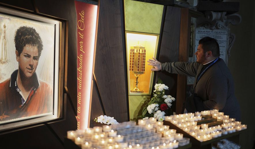 Rev. Cristopher Pujol prays at the heart relic of Carlo Acutis, the 15-year-old Italian boy who died in 2006 of leukemia and was beatified in 2020, at the San Rufino Cathedral in Assisi, Italy, on Wednesday, April 2, 2025. (AP Photo/Alessandra Tarantino) **FILE**