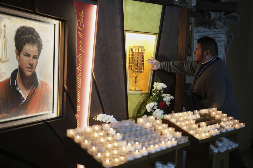 Rev. Cristopher Pujol prays at the heart relic of Carlo Acutis, the 15-year-old Italian boy who died in 2006 of leukemia and was beatified in 2020, at the San Rufino Cathedral in Assisi, Italy, on Wednesday, April 2, 2025. (AP Photo/Alessandra Tarantino) **FILE**