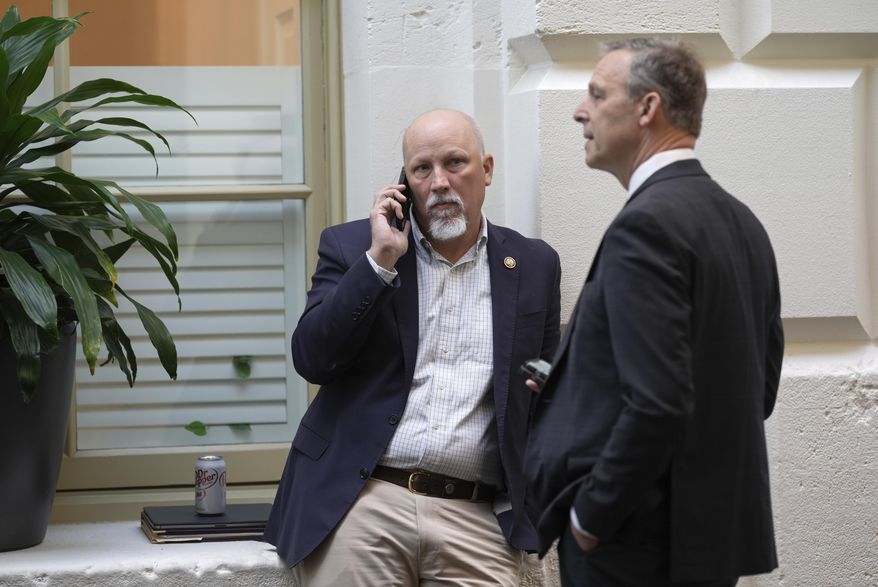Rep. Chip Roy, R-Texas, and Rep. Scott Perry, R-Pa., members of the conservative House Freedom Caucus, meet outside of the closed-door House Republican Conference as Speaker of the House Mike Johnson, R-La., talks to fellow Republicans to push for a House-Senate compromise budget resolution to advance President Donald Trump's agenda, at the Capitol in Washington, Tuesday, April 8, 2025. (AP Photo/J. Scott Applewhite)