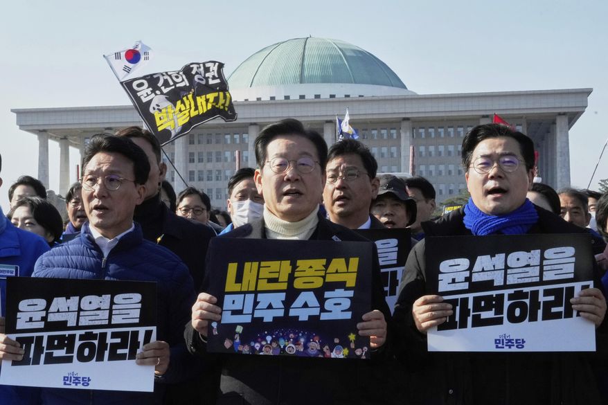 South Korea's main opposition Democratic Party leader Lee Jae-myung, center, and his party members shout slogans during a rally calling for impeached South Korean President Yoon Suk Yeol's dismissal at the National Assembly in Seoul, South Korea, March 19, 2025. The letters read "Dismiss Yoon Suk Yeol." (AP Photo/Ahn Young-joon, File)