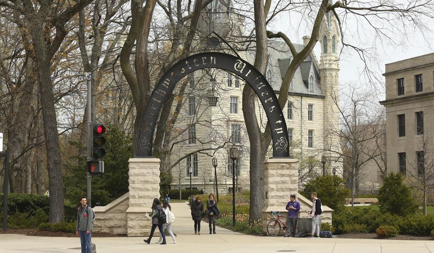 People stand near the entrance gate to Northwestern University in Evanston, Ill., April 29, 2016. (Chris Walker/Chicago Tribune via AP)/Chicago Tribune via AP)