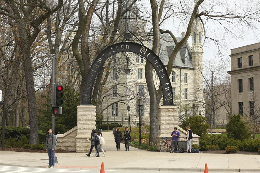 People stand near the entrance gate to Northwestern University in Evanston, Ill., April 29, 2016. (Chris Walker/Chicago Tribune via AP)/Chicago Tribune via AP)