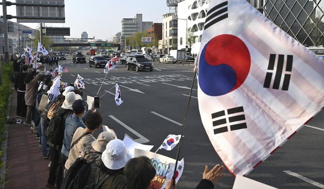 South Korea's ousted president, Yoon Suk Yeol, waves to supporters from his car as he leaves the official residence in Seoul, South Korea, Friday, April 11, 2025. (Jung Yeon-je /Pool Photo via AP)