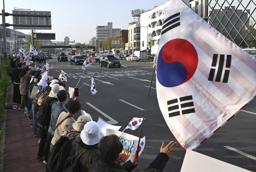 South Korea's ousted president, Yoon Suk Yeol, waves to supporters from his car as he leaves the official residence in Seoul, South Korea, Friday, April 11, 2025. (Jung Yeon-je /Pool Photo via AP)