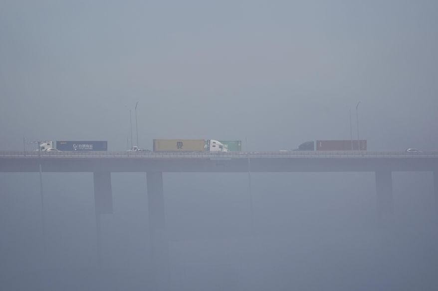 FILE - Trucks carrying shipping containers cross the Long Beach International Gateway Bridge at the Port of Long Beach, Calif., April 8, 2025. (AP Photo/Damian Dovarganes, File)