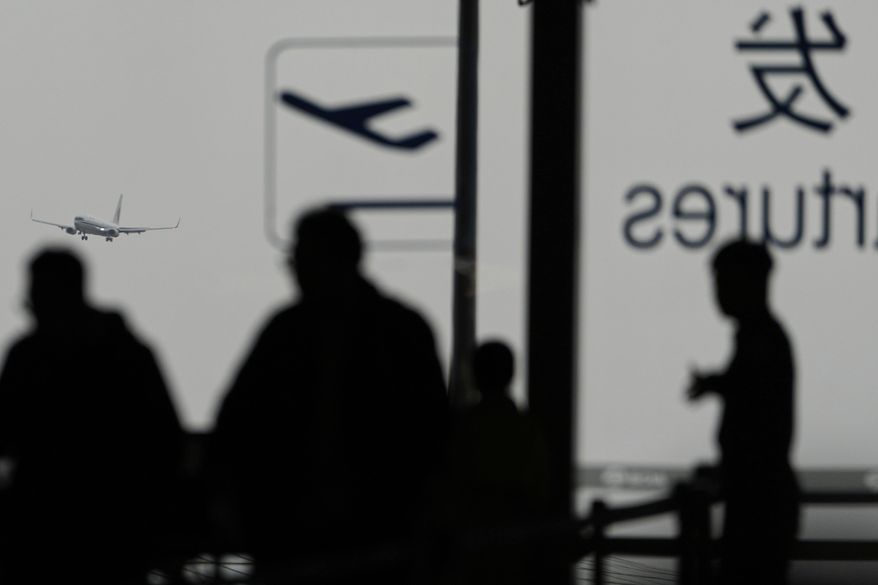 An Air China passenger jet prepares to land at the Beijing Capital International Airport Terminal 3 as gale wind alerts cancelled flights in Beijing, China, Saturday, April 12, 2025. (AP Photo/Ng Han Guan)
