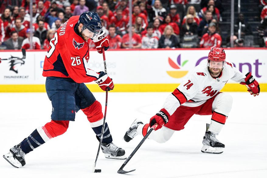 Washington Capitals center Nic Dowd (26) attempts a wrist shot in overtime with Carolina Hurricanes defenseman Jaccob Slavin (74) in his face at Capital One Arena, Washington, D.C., April 10, 2025. (Photo by Brian Murphy for the Washington Times)