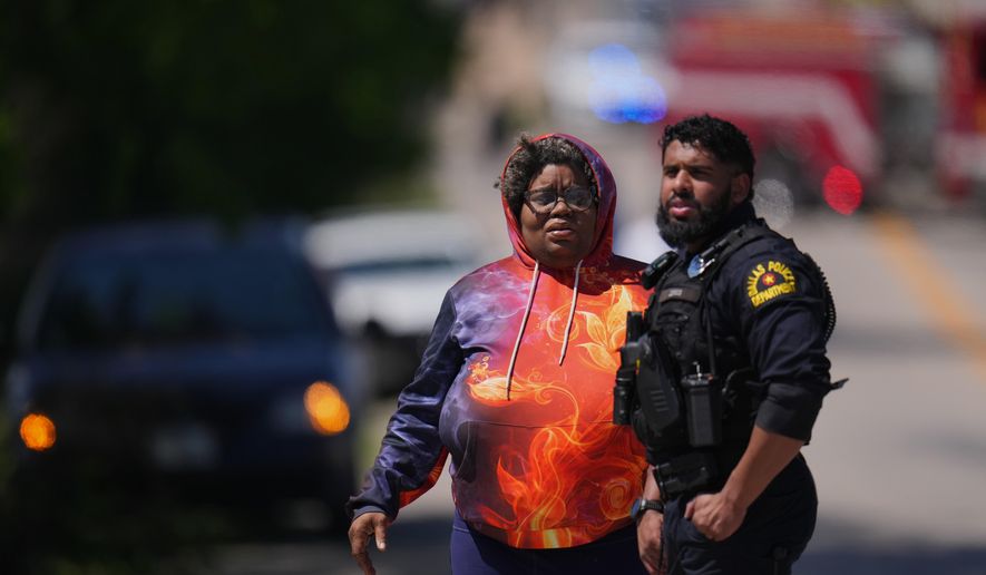 A woman arrives to a checkpoint outside Wilmer-Hutchins High School, where police are responding to reports of a shooting, in Dallas, Tx., Tuesday, April 15, 2025. (AP Photo/Julio Cortez)