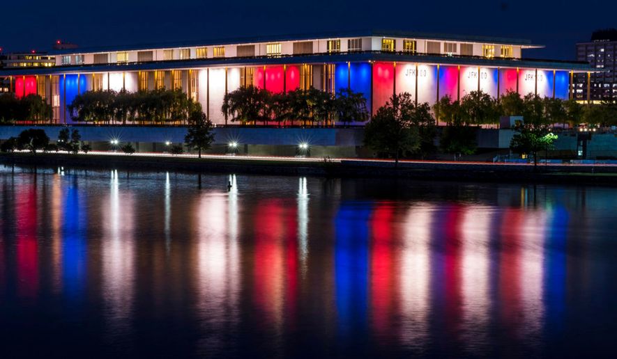 The red, white and blue lights, marking the 100th birthday of President John F. Kennedy, on the outside of the Kennedy Center for the Performing Arts are reflected in the Potomac River in Washington, Friday, May 26, 2017. (AP Photo/J. David Ake)