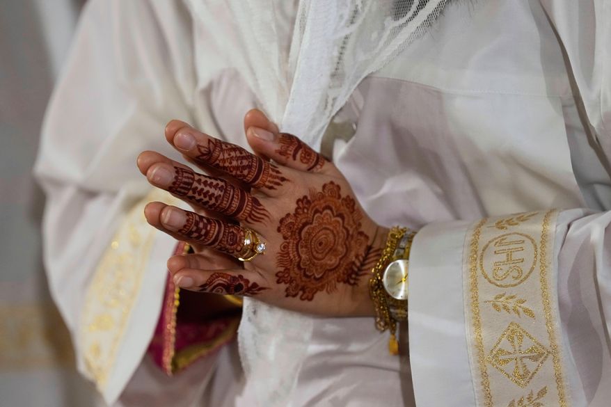 A Christian woman prays during midnight Easter Mass at St. Patrick's Cathedral Church, in Karachi, Pakistan, Sunday, April 20, 2025. (AP Photo/Fareed Khan)