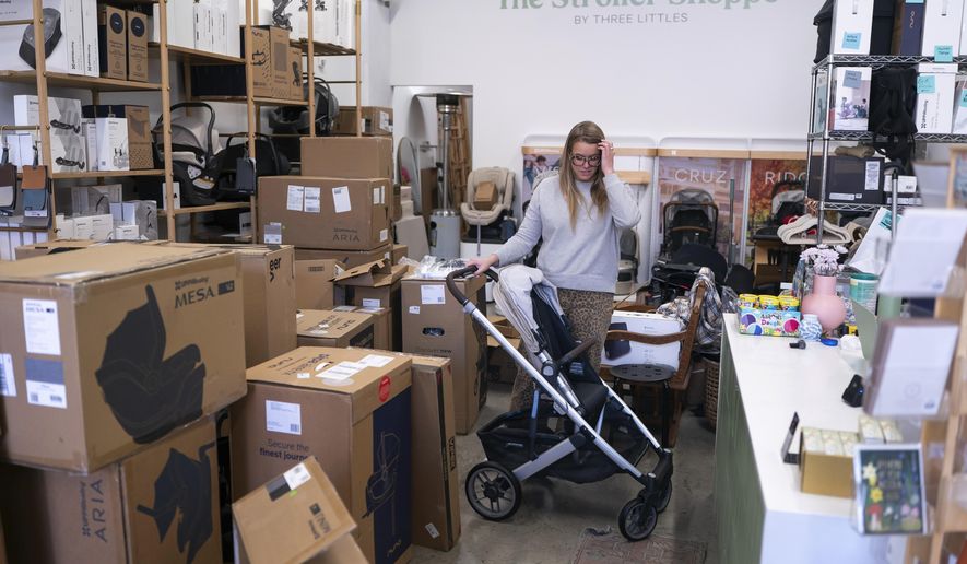 Elizabeth Mahon, owner of baby store Three Littles, unpacks strollers and other inventory ordered by customers ahead of tariff-driven price increases at her Union Market location in Washington, on Wednesday, April 16, 2025. (AP Photo/Nathan Howard)
