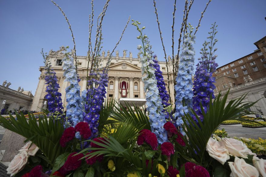 Flowers are set up for the Easter mass in St. Peter's Square at the Vatican Sunday, April 20, 2025. (AP Photo/Andrew Medichini)