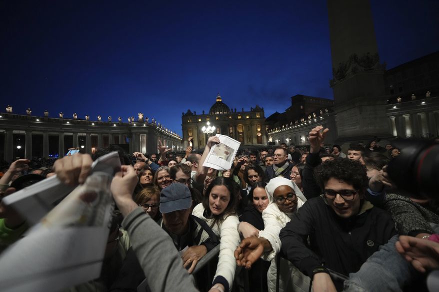 Copies of the Vatican paper L'Osservatore Romano are distributed after a rosary prayer for the late Pope Francis, in St. Peter's Square at the Vatican, Monday April 21, 2025. (AP Photo/Alessandra Tarantino)