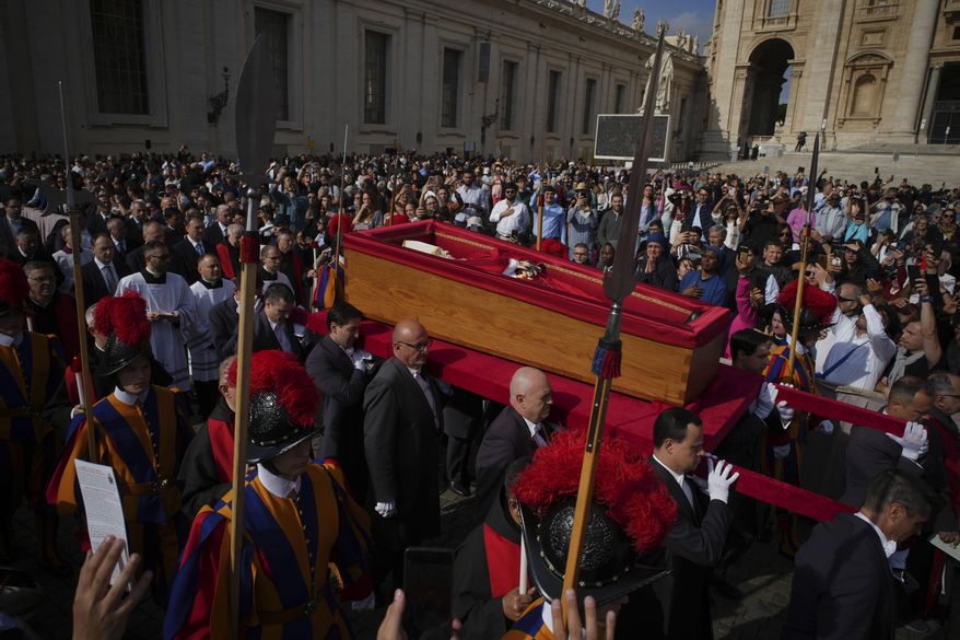 The body of Pope Francis is carried into St. Peter's Basilica at the Vatican, Wednesday, April 23, 2025, where he will lie in state for three days. (AP Photo/Emilio Morenatti)