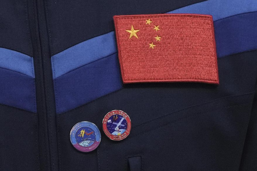 A Chinese national flag and pins showing the Tiangong space station are displayed on a uniform of Chinese astronaut for the upcoming Shenzhou-20 mission during a meeting with media at the Jiuquan Satellite Launch Center in northwest China, Wednesday, April 23, 2025. (AP Photo/Andy Wong)