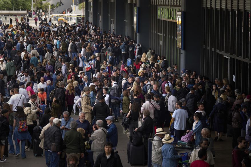 People wait outside a closed train station, during a major power outage in Barcelona, Spain, Monday, April 28, 2025. (AP Photo/Emilio Morenatti)